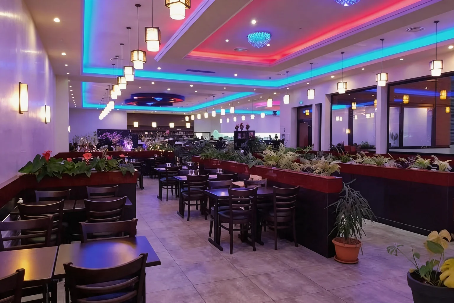 Dining room with a blue and pink lit ceiling, lanterns and planters.